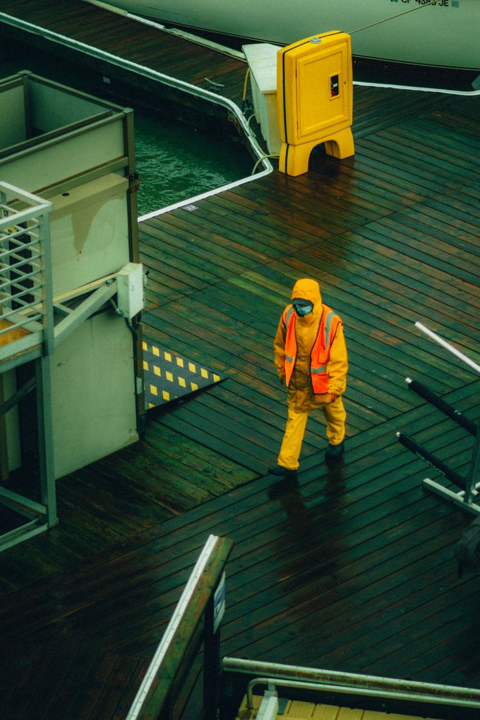 A worker in rain gear walking on a San Francisco dock, illustrating urban work life.